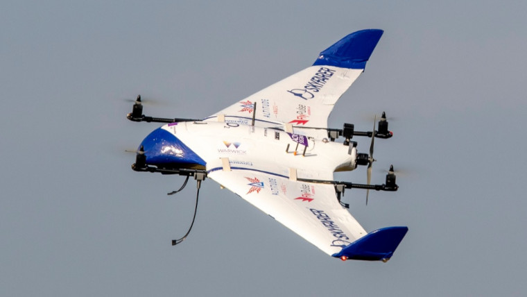 A drone flying with a grey sky in the background