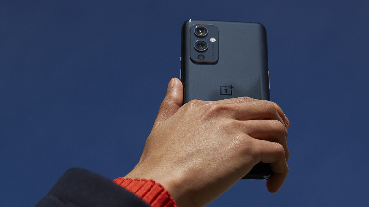 OnePlus 9 in Astral Black being held in the air