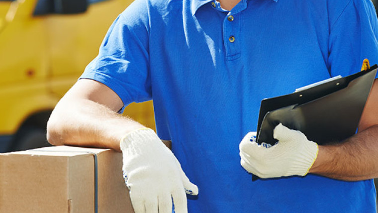 amazon worker leaning on box with white gloves on