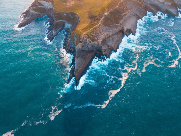 An aerial photo of the Cape with blue waters and foaming waves