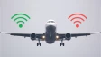 An airplane in the air with green and red Wi-Fi symbols on either wing