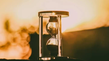 hourglass against a sunset backdrop