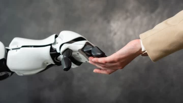 A robot hand holding a human hand