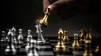 A hand performing a checkmate on a chess board