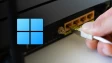Man unplugging Ethernet cable from a router with a Windows 11 logo