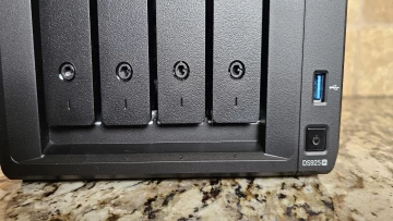 Closeup photo of the Synology DS925 drive bays with the sleds inserted and the model number displaye