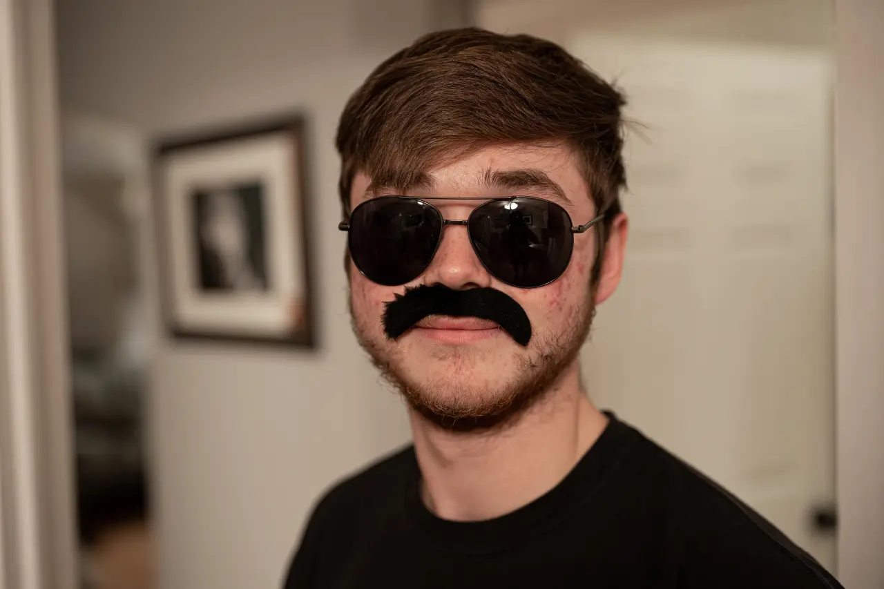 A person wearing a clearly fake moustache