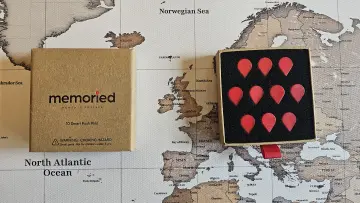 Photograph of a box of Memoried Memory Pins on a map showing UK Francnce Spain and Iceland